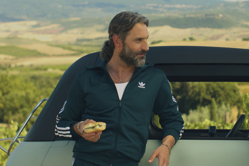Lorenzo (Marco Calvani) holding a sandwich in You, Me & Tuscany (2026).