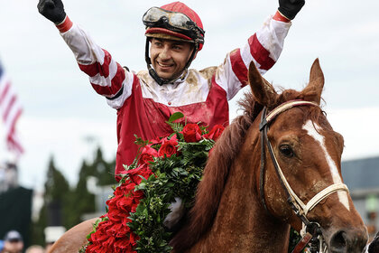 Kentucky Derby-winning team with garland of roses over the horse