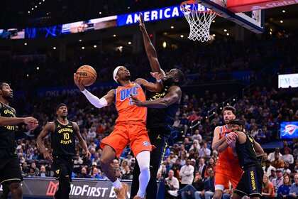 Shai Gilgeous-Alexander #2 of the Oklahoma City Thunder attempts a shot in front of Draymond Green #23 of the Golden State Warriors/