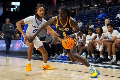 North Carolina A&T Aggies Guard Jahnathan Lamothe, #5, dribbles the ball against the Hofstra Pride.