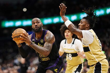 LeBron James of the Los Angeles Lakers looking to shoot the ball past two Washington Wizards players.