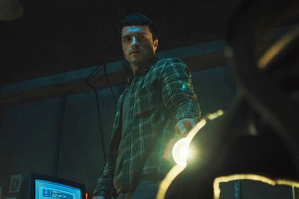 Mike looking down at a animatronic head in Five Nights at Freddy's (2025).