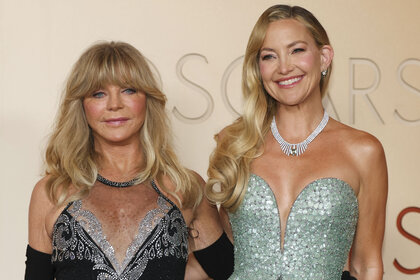 Goldie Hawn and Kate Hudson posing together in front of a step and repeat.