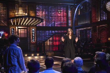 Tina Fey talks onstage in Saturday Night Live UK Season 1 Episode 1.