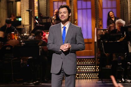 Harry Styles in a gray suit on stage during the monologue on Saturday Night Live Season 51 Episode 15.