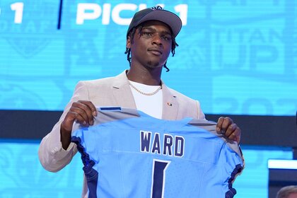 Cam Ward holding up a Tennessee Titans jersey at the 2025 NFL Draft.