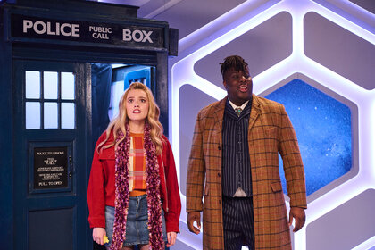 Aimee Lou Wood and Hammed Animashaun in front of a police station set.