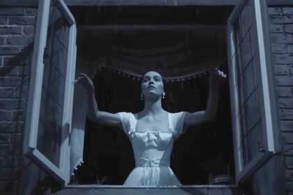 Lily Rose Depp as Ellen Hutler standing at an open window.