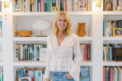Elin Hilderbrand standing in front of her home Library.