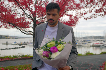 Felipe Cruz holding a bouquet of flowers at a park.