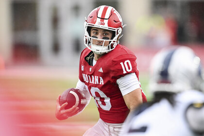 Quarterback Josh Hoover, #10 of the Indiana Hoosiers, runs with the ball during a game.