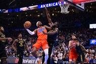 Shai Gilgeous-Alexander #2 of the Oklahoma City Thunder attempts a shot in front of Draymond Green #23 of the Golden State Warriors/