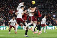 Declan Rice of Arsenal heads clear under pressure from AFC Bournemouth's James Hill during a Premier League match.