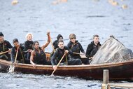 Rob Rausch, Porsha Williams, Dorinda Medley, Natalie Anderson, Tiffany Mitchell, Rob Cesternino, Lisa Rinna, and Ian Terry rowing a boat on The Traitors Season 4 Episode 1.