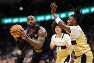 LeBron James of the Los Angeles Lakers looking to shoot the ball past two Washington Wizards players.