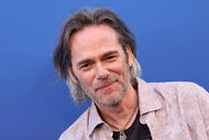 Billy Burke in front of a blue backdrop.