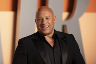 Vin Diesel smiling in front of a step and repeat.