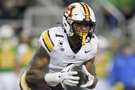 Darius Taylor, #1 of the Minnesota Golden Gophers, holding a football during a game.