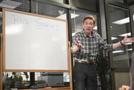 Ned Sampson (Domhnall Gleeson) writing on a whiteboard in The Paper Season 2.
