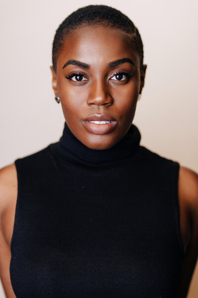 Devin Kessler wearing a black turtle neck top.