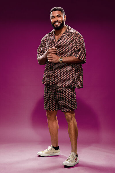 Johnny Middlebrooks standing in front of a purple backdrop in House of Villains Season 3.