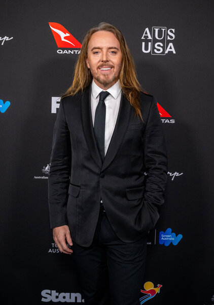 Tim Minchin wearing a suit on a red carpet arrival.