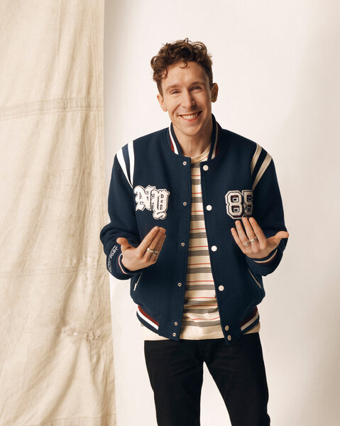Larry Dean posing in front of a cream backdrop.