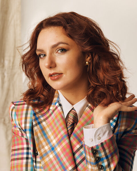 Ania Magliano posing in front of a cream backdrop.
