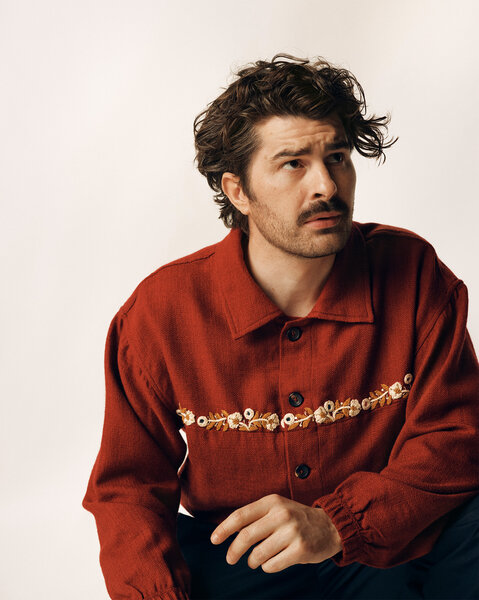 Paddy Young posing in front of a cream backdrop.