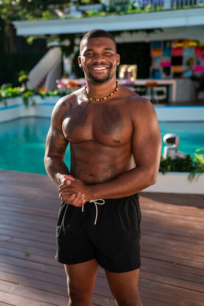 Jalen Brown in swim shorts in front of the Love Island pool