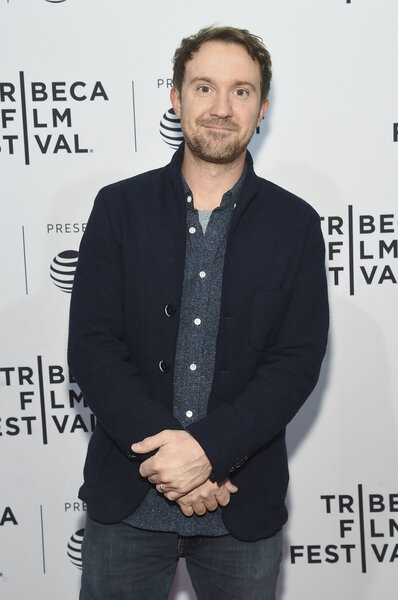Sam Huntington posing in front of a step and repeat.