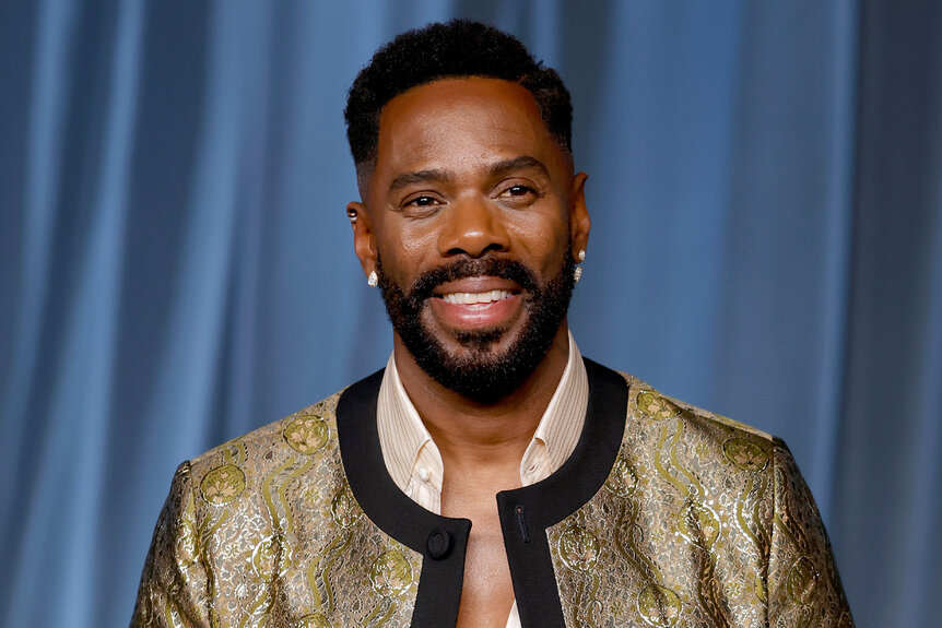 Colman Domingo smiles in a gold and black jacket.