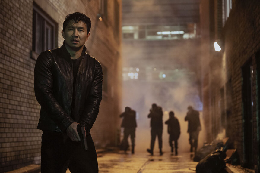 Alexander (Simu Liu) holding a weapon in The Copenhagen Test Season 1 Episode 4.