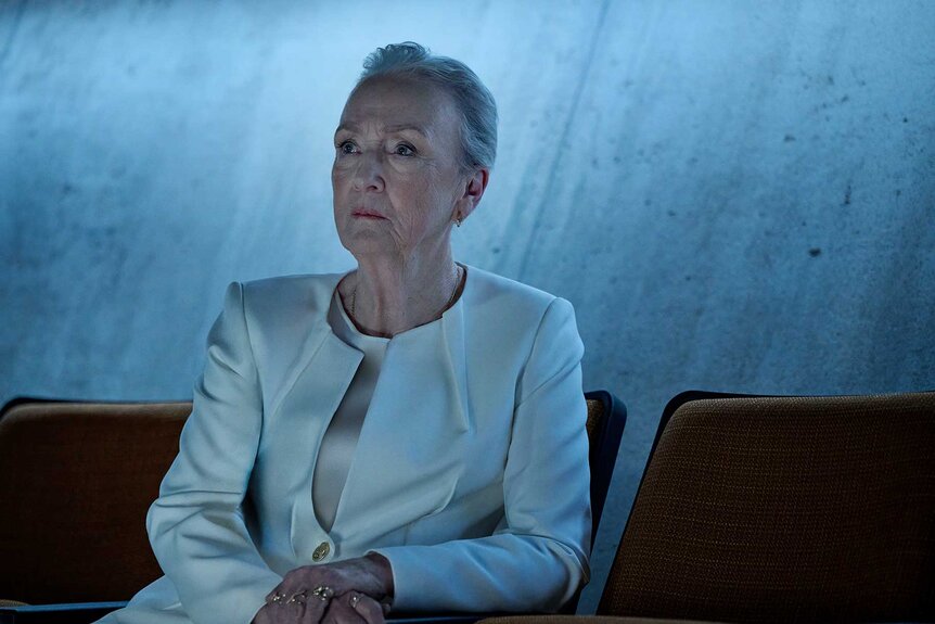 St. George sitting and looking up in The Copenhagen Test Season 1 Episode 5.