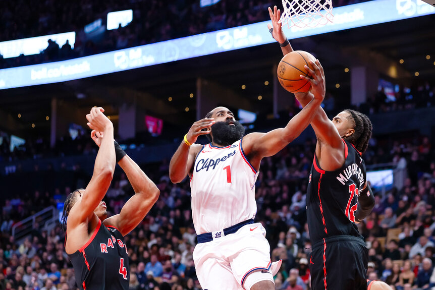 James Harden of the Los Angeles Clippers drives to the net between Scottie Barnes and Collin Murray-Boyles of the Toronto Raptors.