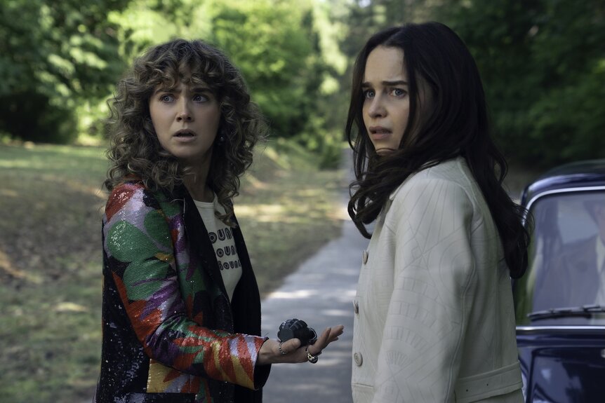 Twila (Haley Lu Richardson) and&nbsp;Bea (Emilia Clarke) stand outside a vechicle on Ponies Episode 108.