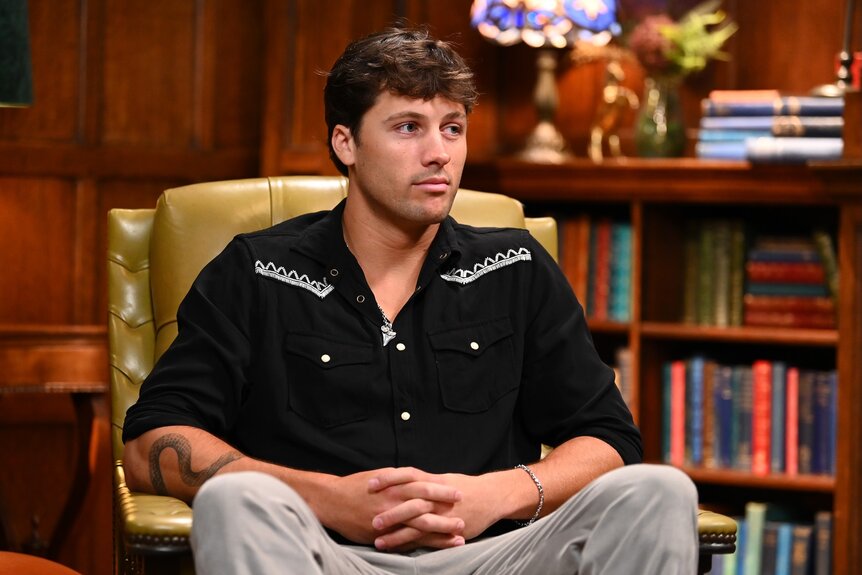 Rob Rausch sits in an armchair on The Traitors Episode 401.