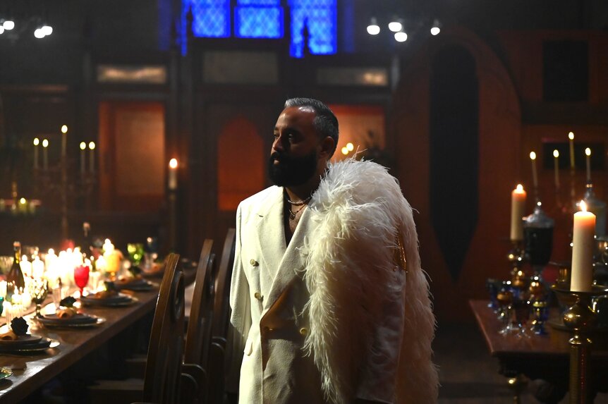Yamil "Yam Yam" Arocho wears a white outfit with feathers on The Traitors Episode 407.