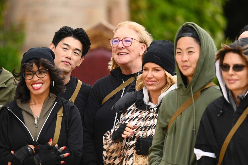 Tiffany Mitchell, Eric Nam, Donna Kelce, Caroline Stanbury, Kristen Kish, and Lisa Rinna smiling outside on The Traitors Season 4 Episode 2.&nbsp;