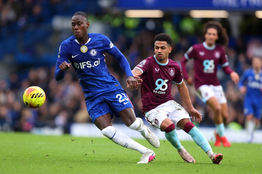 Trevoh Chalobah of Chelsea and Marcus Edwards of Burnley chase the ball during a match.