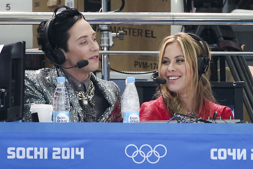 Tara Lipinski and Johnny Weir sitting and commentating at the 2014 Sochi Olympics.