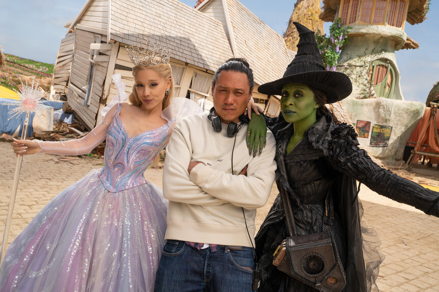 L to R: Ariana Grande (as Glinda), Director Jon M. Chu, and Cynthia Erivo (as Elphaba), on the set of WICKED FOR GOOD, directed by Jon M. Chu.