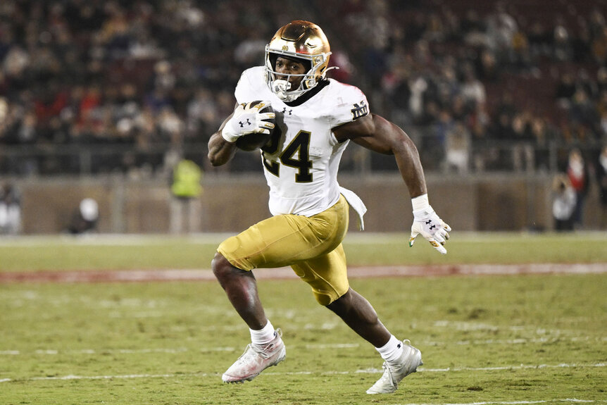 Jadarian Price, #24 of the Notre Dame Fighting Irish, running with the football during a game.