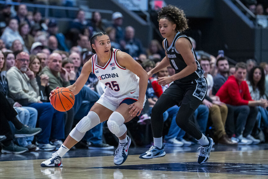 Azzi Fudd, #35 of the Connecticut Huskies, plays against Khadee Hession, #8 of the Georgetown Hoyas at a basketball game.