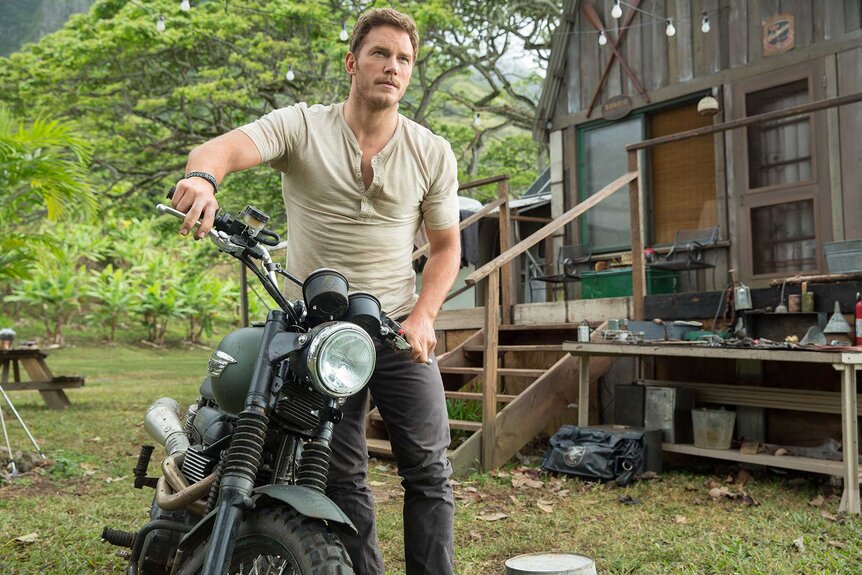 Owen Grady riding a motorcycle outside during&nbsp;Jurassic World (2015).