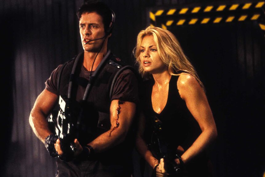 Books and Princess Zarina holding guns in Leprechaun 4 (1996).