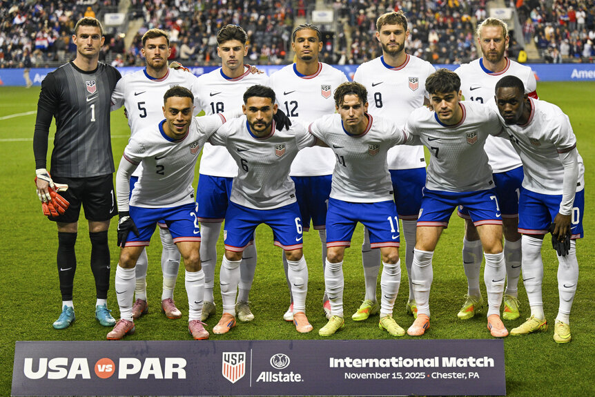 The US Mens National Soccer Team posing on a field ahead of a match.