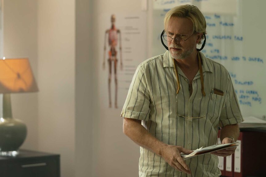Kincaid holding a book with glasses on in M.I.A. Season 1 Episode 4.