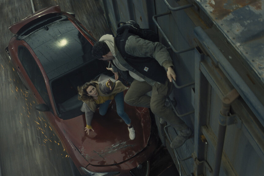 Emily Blunt being pulled onto a moving train by Josh O'Connor in Disclosure Day (2026).