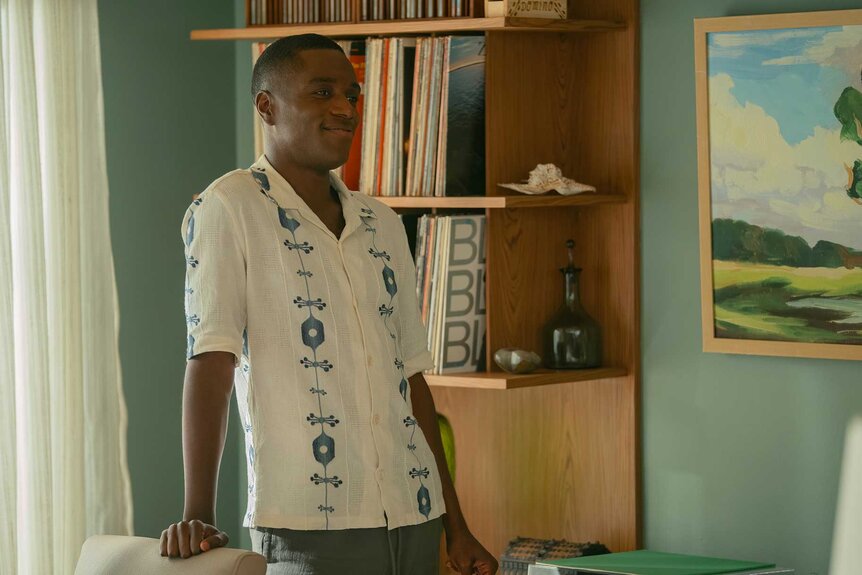 Stanley leaning against a chair in M.I.A. Season 1.